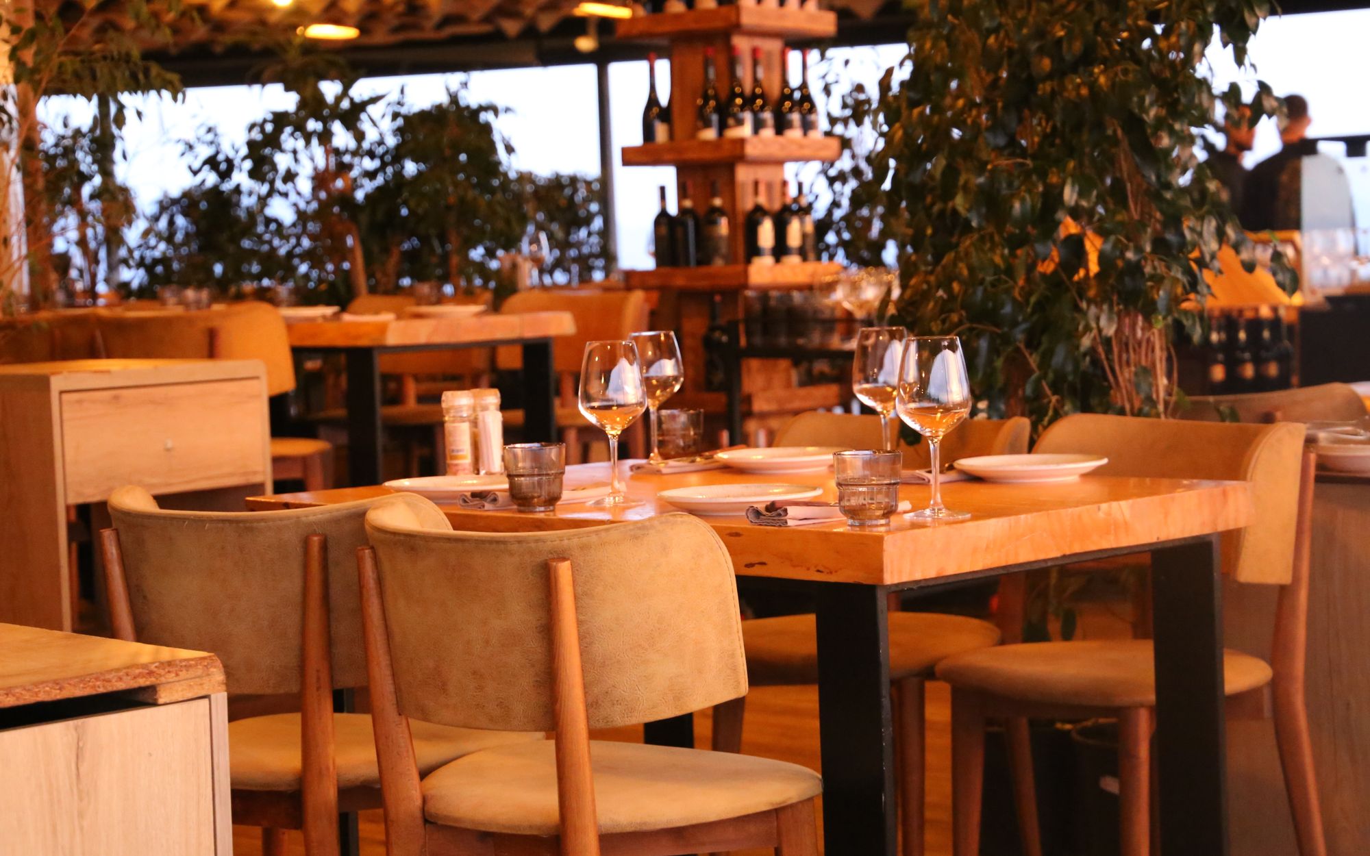 Warm, candlelit dining room at Sol y Sabor set for evening service